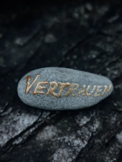 Vertrauen in goldener Schrift auf Stein