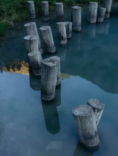 Weg Pflöcke Berge spiegeln sich im Wasser
